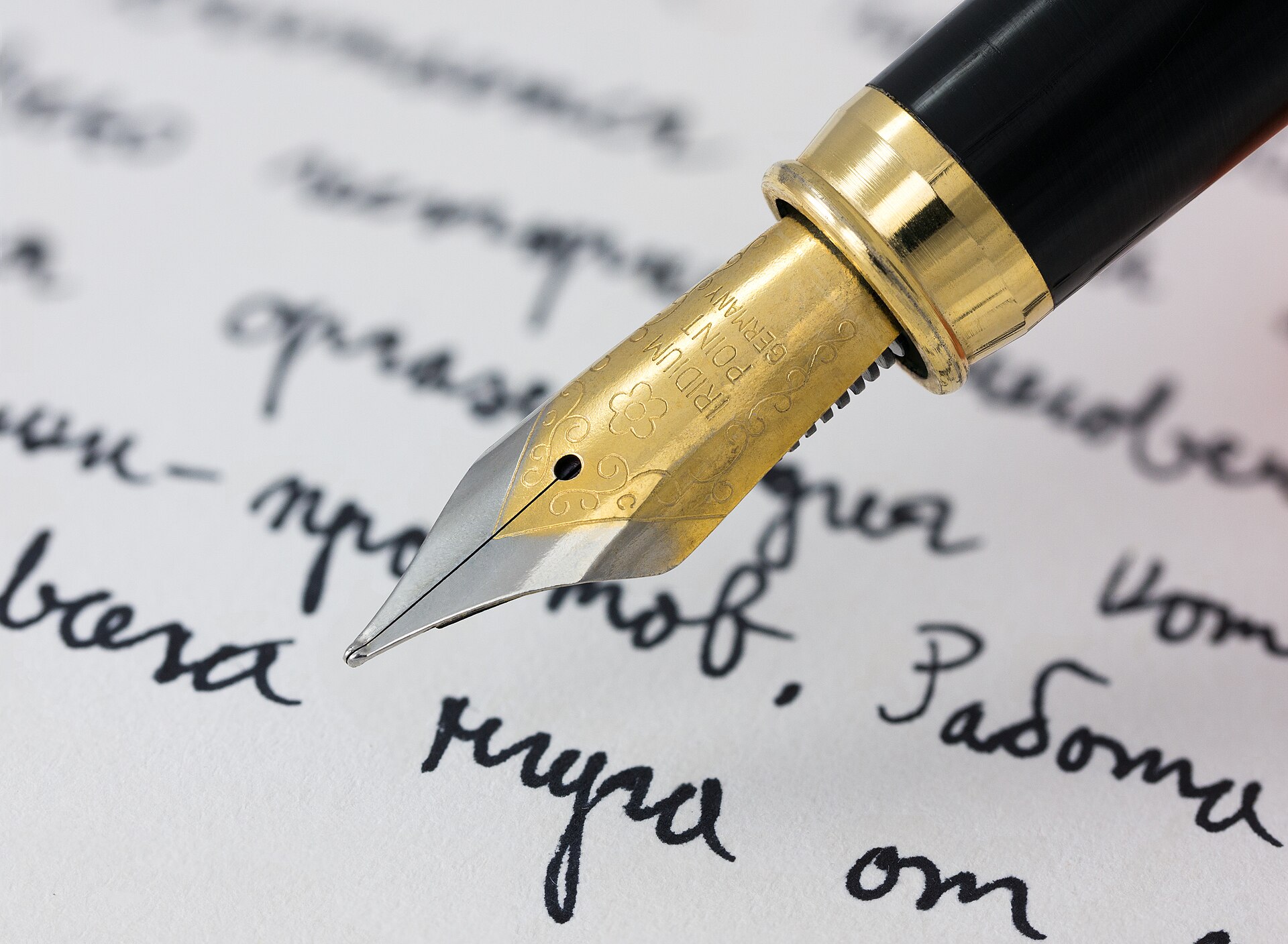 Cyrillic Script | Online Stars A gold fountain pen writes Cyrillic script on paper, illustrating the power of compelling content.